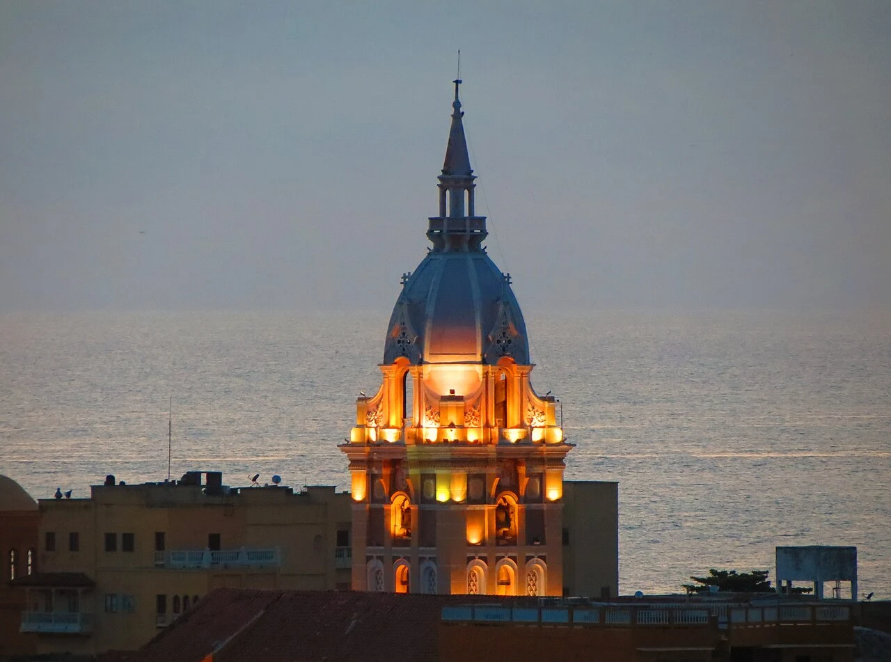 Torre de la Catedral de Santa Catalina de Alejandría iluminada al atardecer, con el mar Caribe al fondo